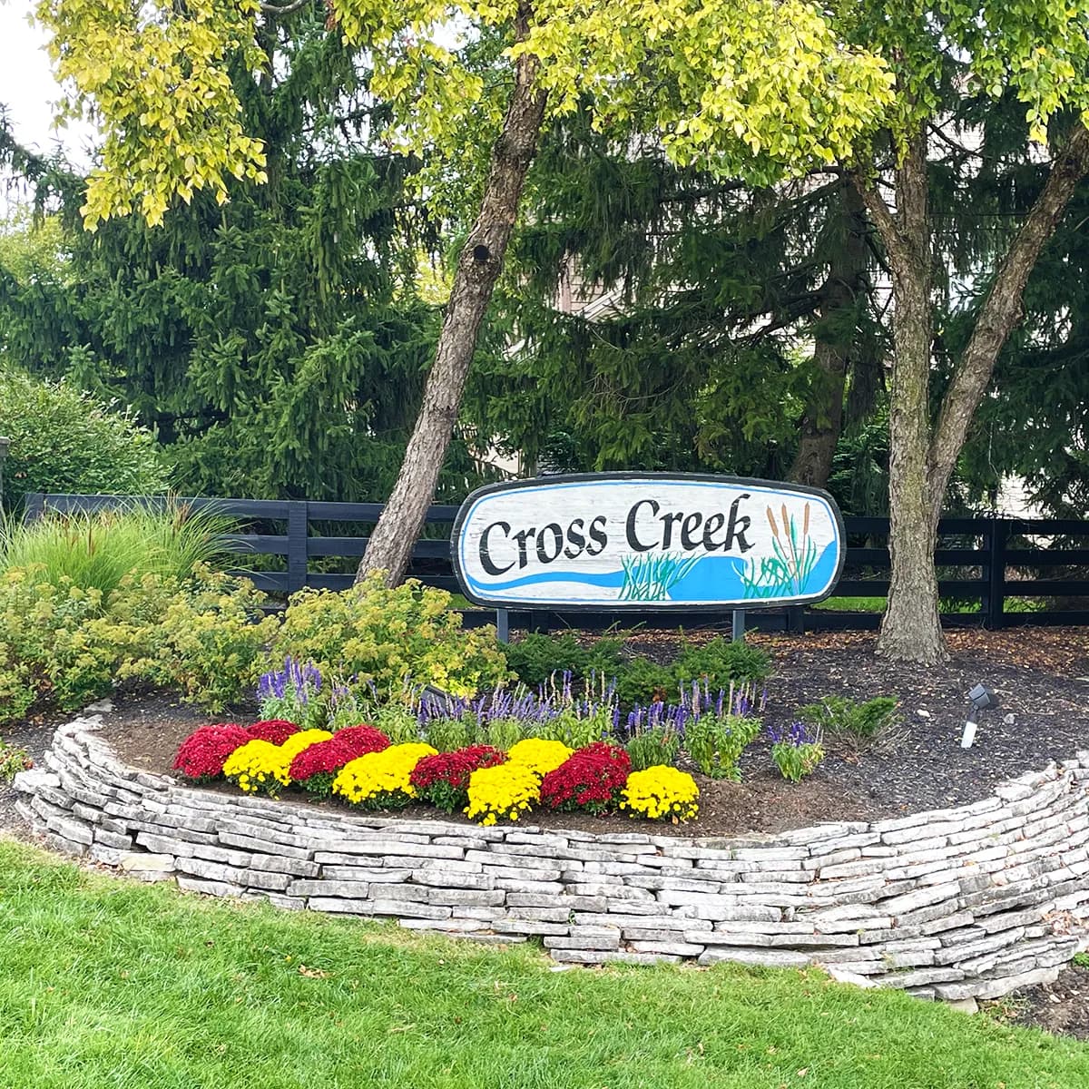 Manicured commercial community entrance with stone bed and flowers